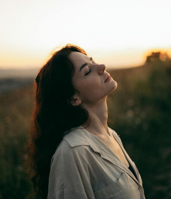 Woman feeling energized and peaceful in a bright, natural setting.
